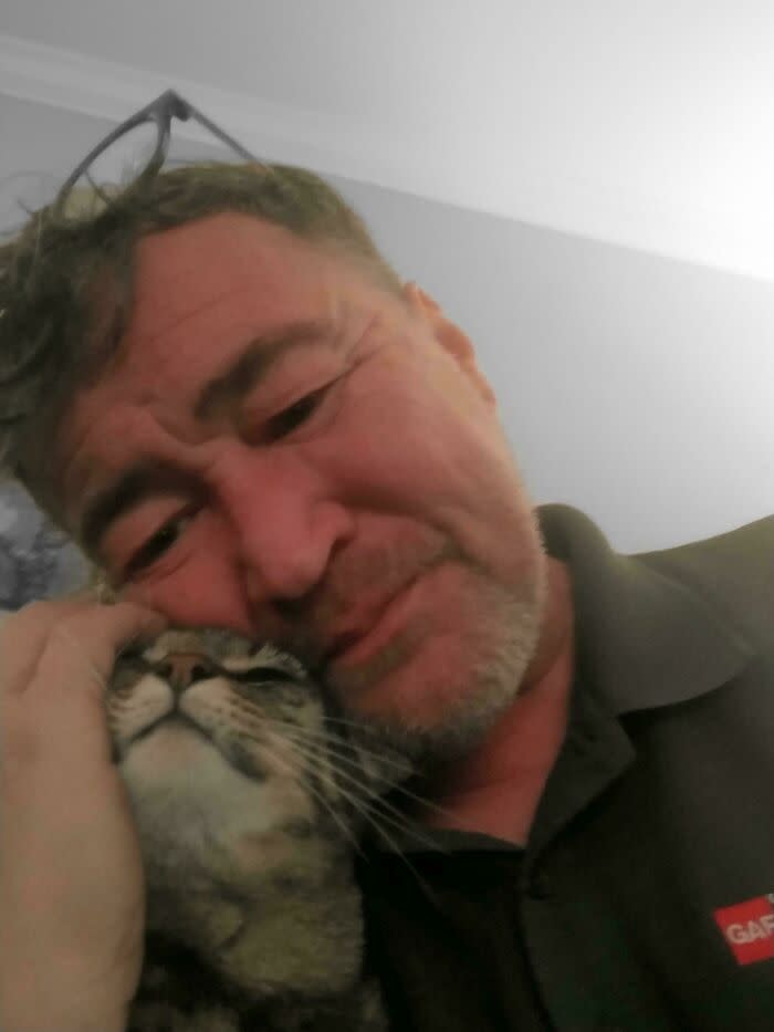 A tender moment between a man and his content cat showcasing love and companionship.