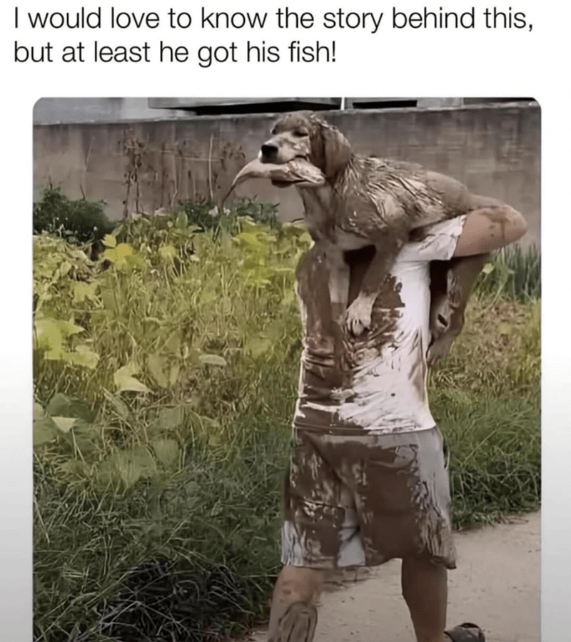 Humorous mud-covered dog with a fish and owner after playful outdoor adventure.