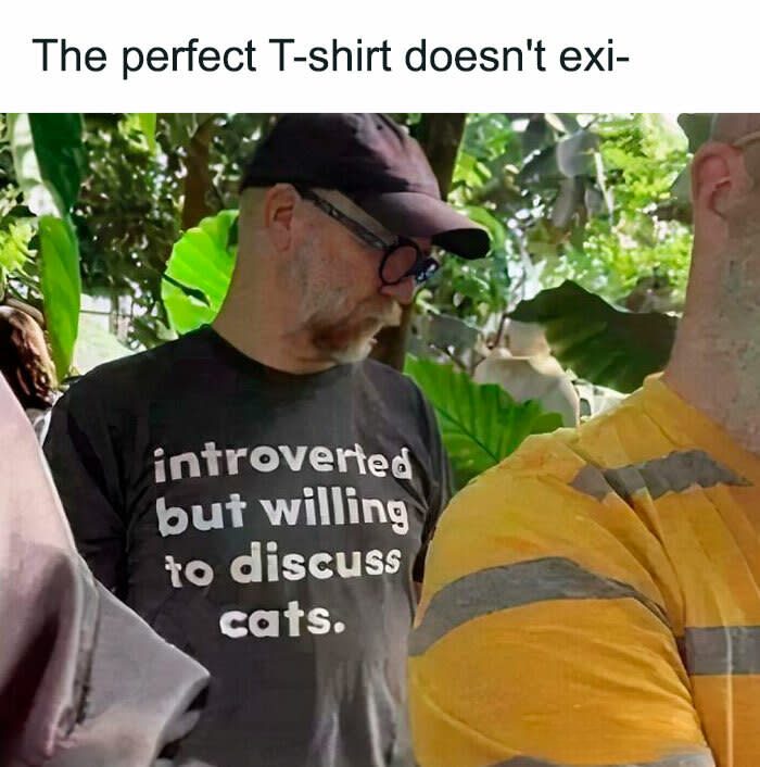 Introverted cat lover wearing funny T-shirt outdoors with green garden background.