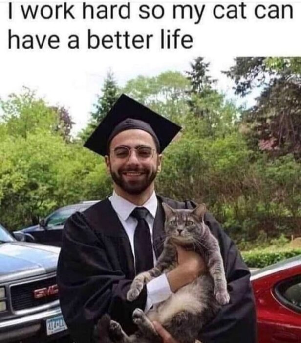 Graduation celebration with a proud young man and relaxed gray tabby cat outdoors.