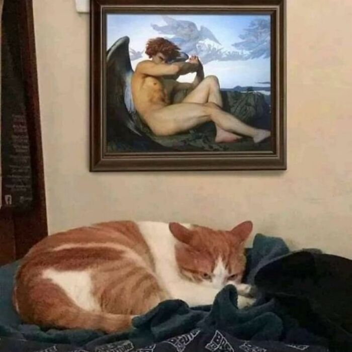 Cozy room with sleeping cat and serene angel painting on wall.